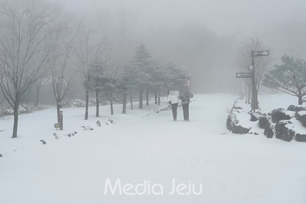 14일 오전 한라산 탐방객이 눈 내린 어리목광장을 걸어나오고 있다. © 미디어제주