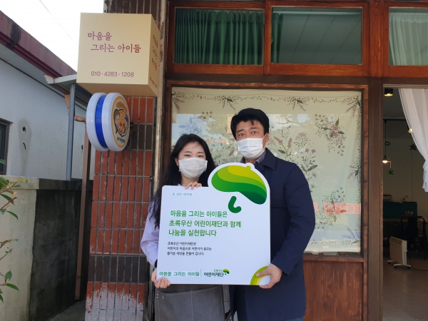 ※사진설명(사진=초록우산어린이재단 제주지역본부)사진 1) 22일(월) 마음을 그리는 아이들 김수련 원장(왼쪽)은  초록우산 어린이재단을 통해 매월 수익금 일부를 후원하는 나눔현판에 동참하였다.