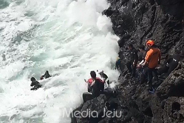 26일 서귀포해양경찰서 관계자들이 갯바위 낚시를 하다 파도에 휩쓸린 안모(53)씨를 구조하고 있다. [서귀포해양경찰서 제공]