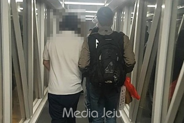 지난 4일 베트남 현지에 불법 음란물 수천개를 파일 공유사이트에 올린 용의자 김모(38)씨 신병을 확보한 경찰이 떤선넛국제공항에서 함께 이동하고 있다. [제주지방경찰청]