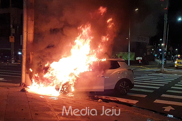 18일 새벽 제주 동부경찰서 사거리에서 전봇대를 들이받은 차량이 불에 타고 있다. [제주소방서]