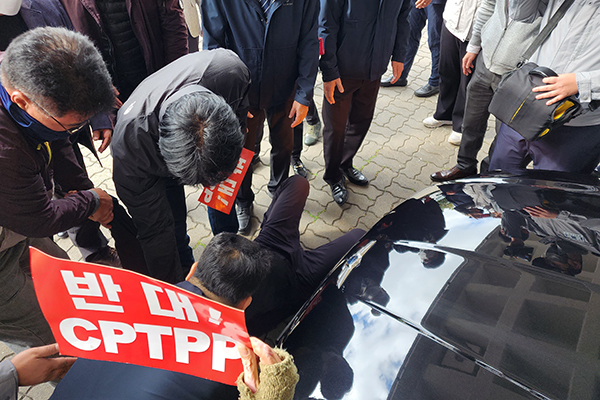 14일 오전 농민단체 관계자가 제주도의회 앞에서 외부 일정을 위해 이동 중이던 김경학 의장의 차량을 막아서고 있다.